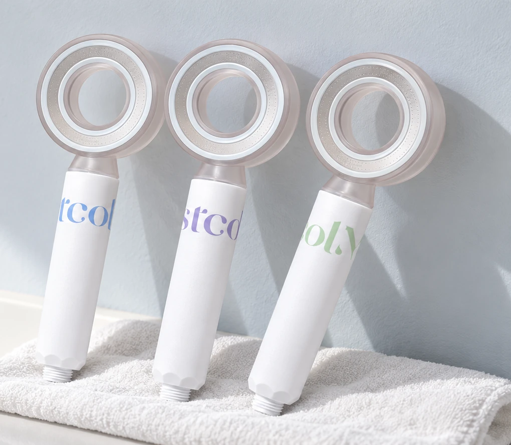 Three MOSTCOL shower heads with blue, purple and green accents in a bright bathroom setting